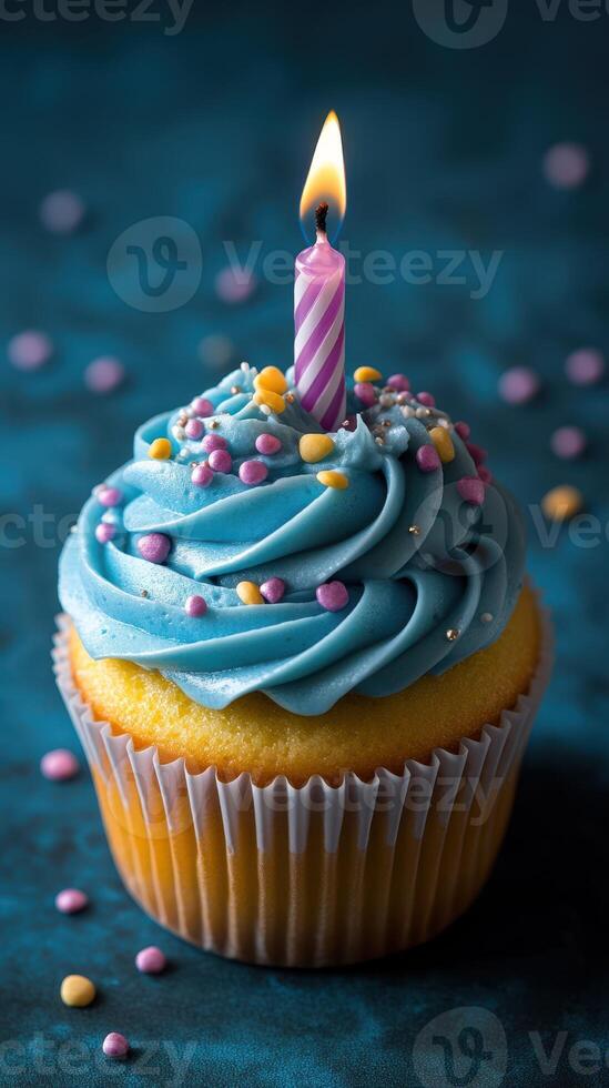 Colorful birthday cupcake with blue frosting and a single candle on a decorative background photo