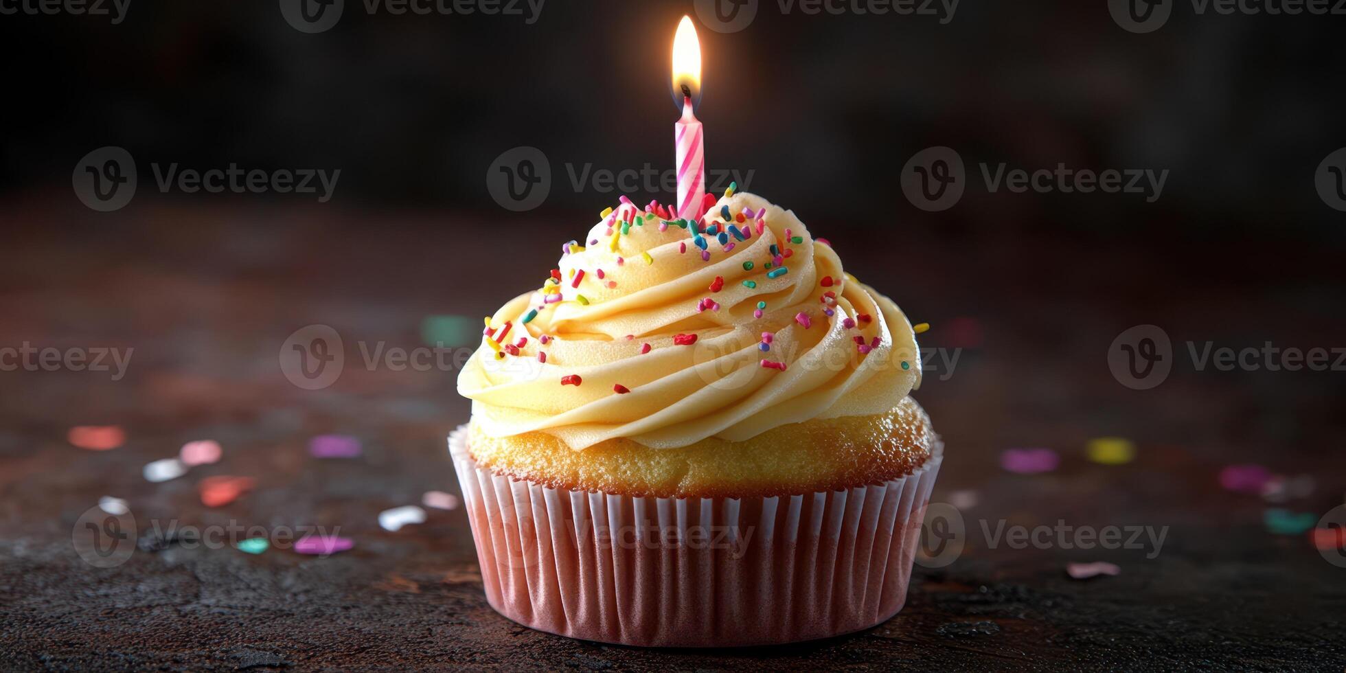 Delicious yellow frosted cupcake with a single pink candle and colorful sprinkles for a festive celebration photo