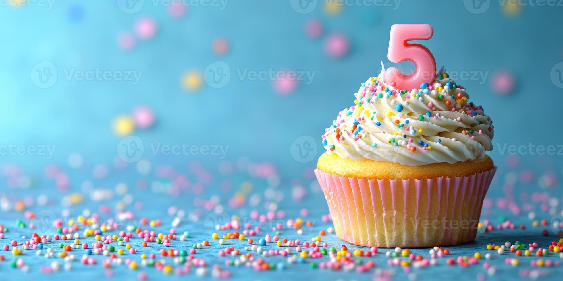 Colorful cupcake with sprinkles and a birthday candle number five on bright blue background celebrating a child's special day photo