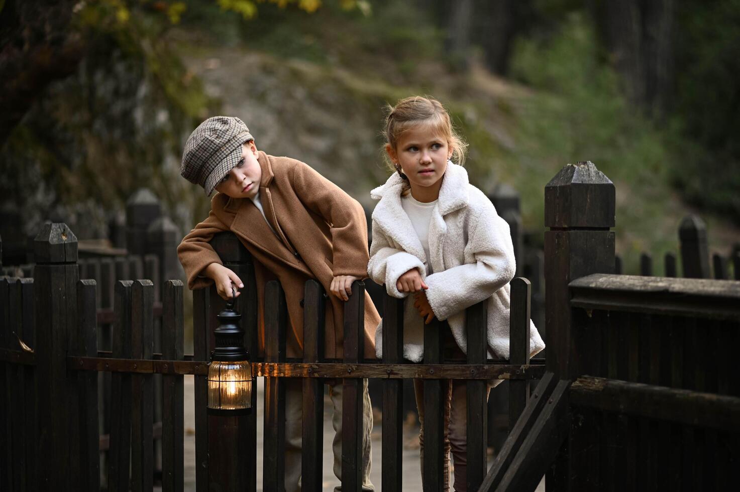 a boy and girl with fading light in a hands stand on man old wooden bridge at dusk, wrapped in the glow of a vintage lantern photo