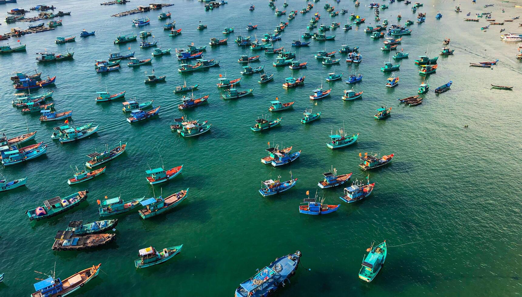 A lively harbor filled with multicolored fishing boats on the water in Vietnam photo