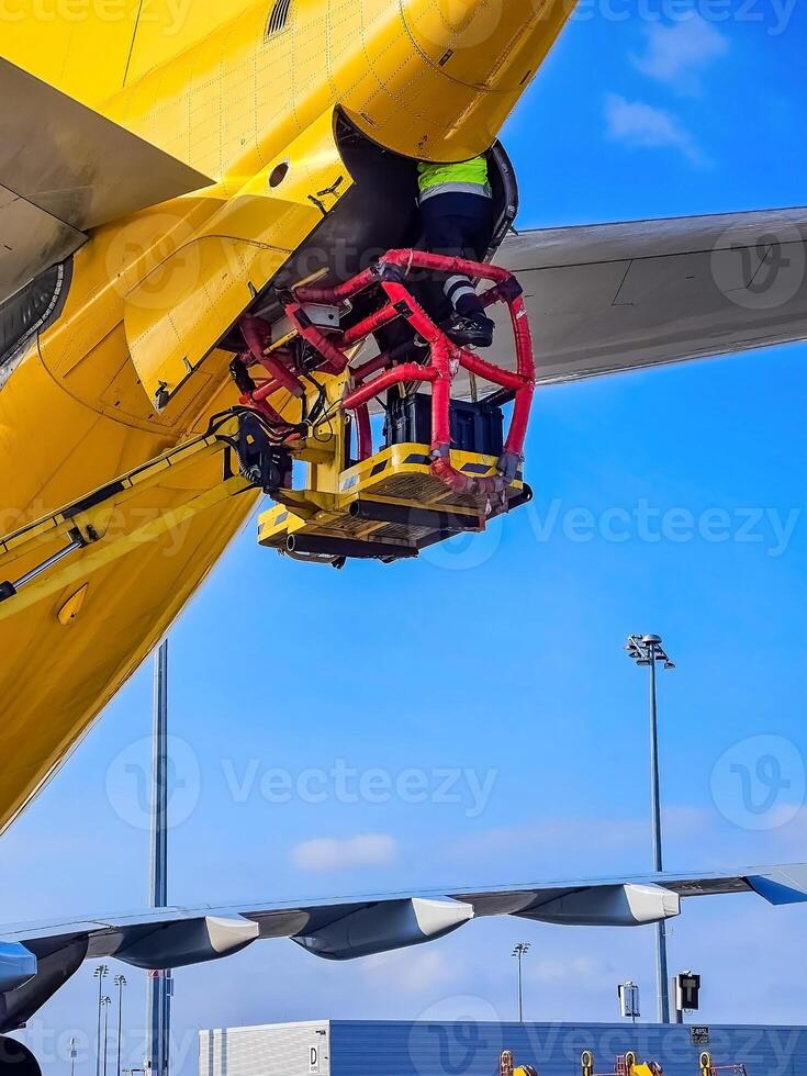 Aircraft maintenance work under the yellow fuselage with hydraulic lift. High quality photo
