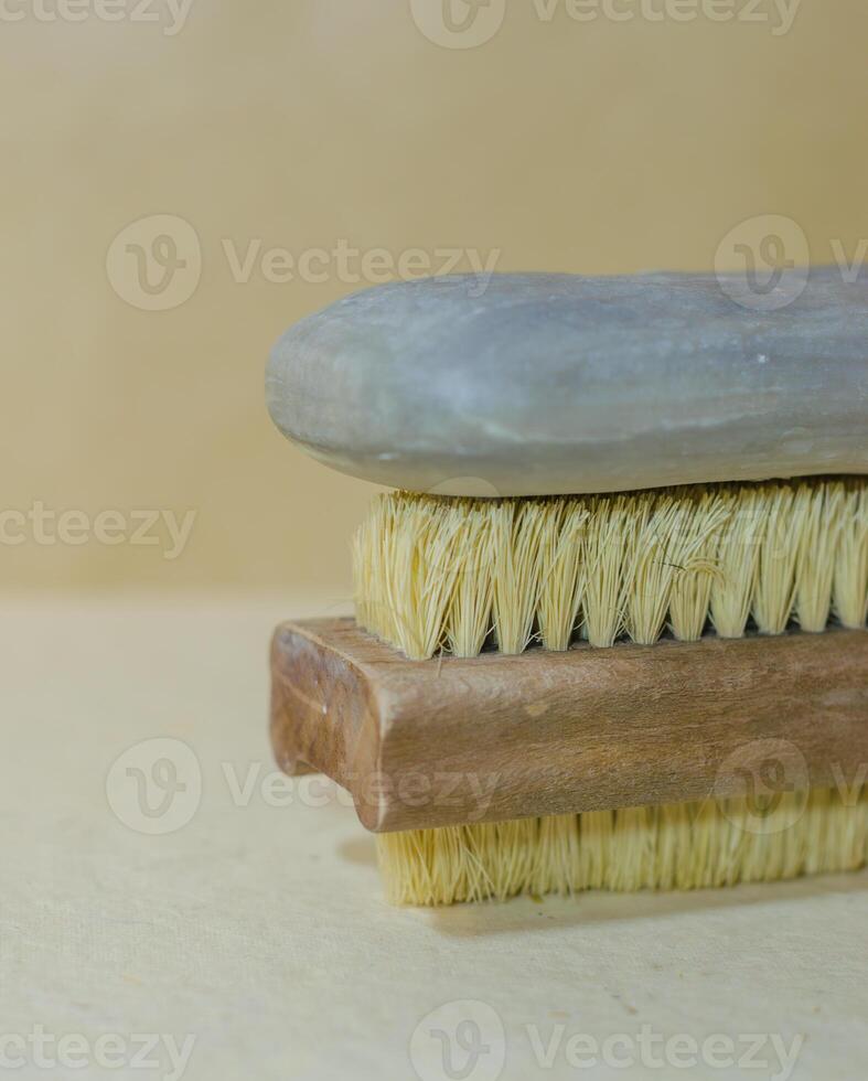 Natural soap bar placed on a wooden cleaning brush with stiff bristles. High quality photo