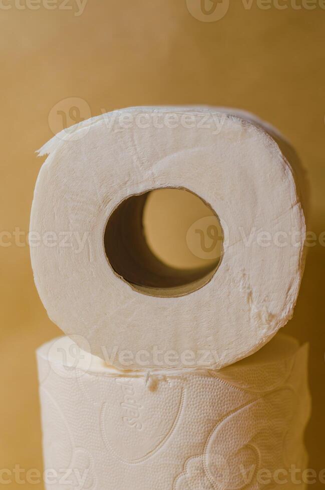 Close-up of stacked toilet paper rolls on a beige background in soft lighting. High quality photo