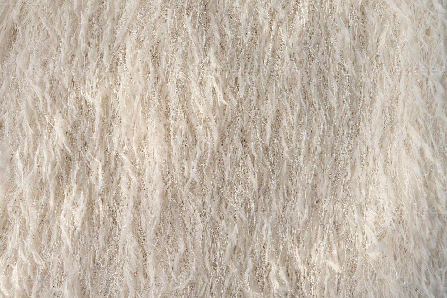 Feathered textured fabric with metallic threads in beige colour, fashion textile close-up. photo