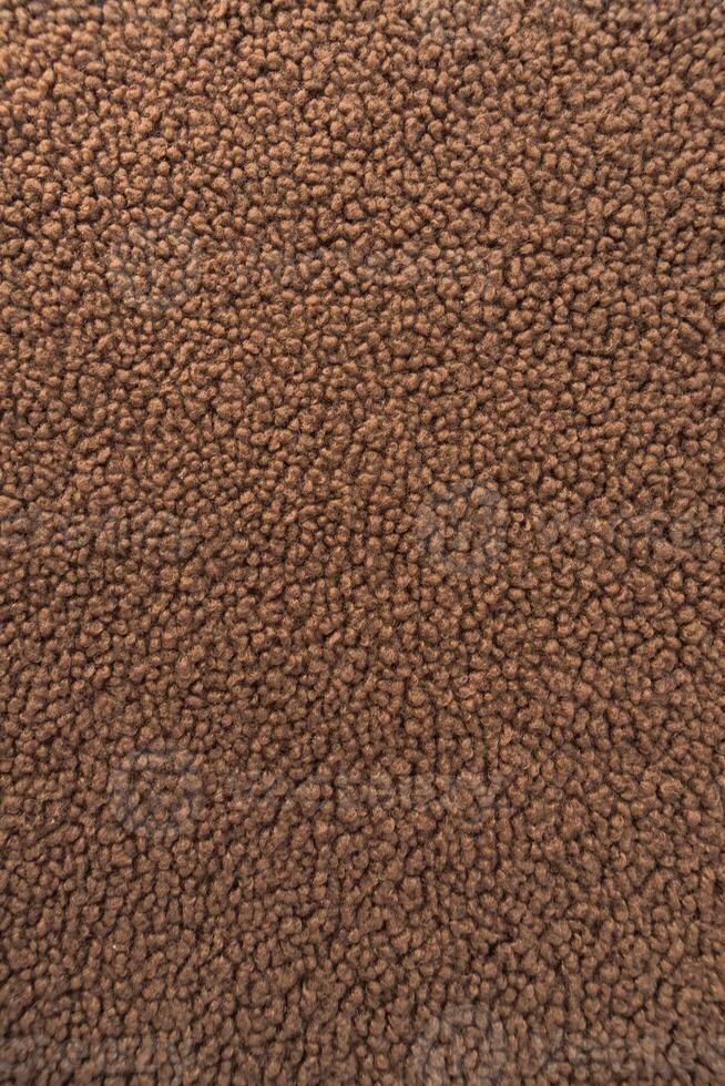 Macro shot of brown fashion teddy sherpa fleece fabric showcasing its soft curly texture. photo