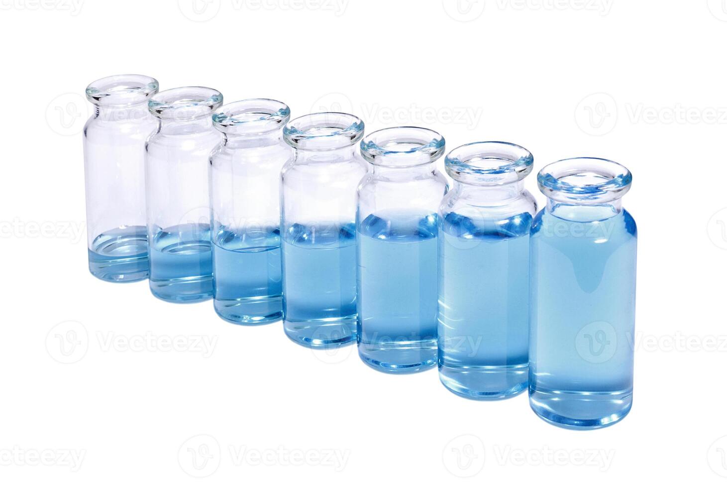 A row of phials with blue vaccine on white background photo