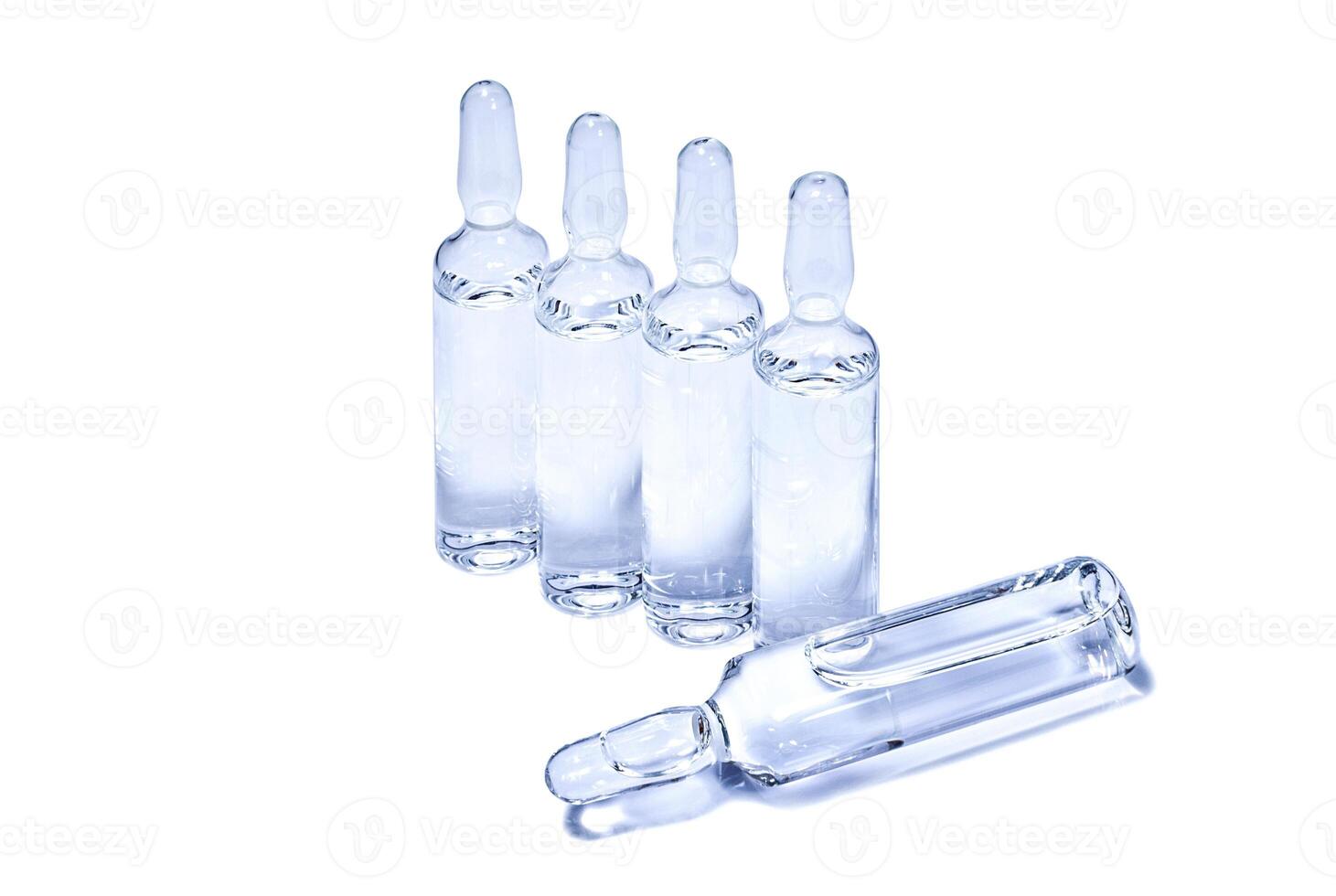 Ampules with transparent vaccine on white background photo