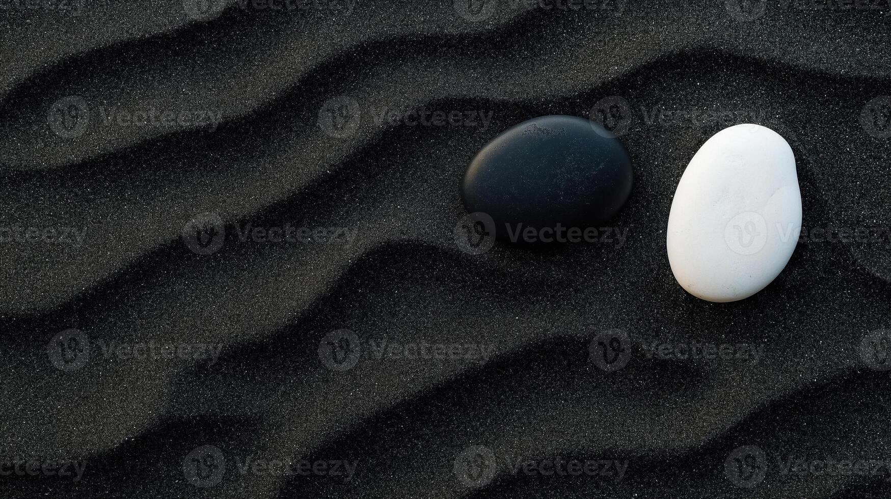 Two black and white stones on a black sand beach photo