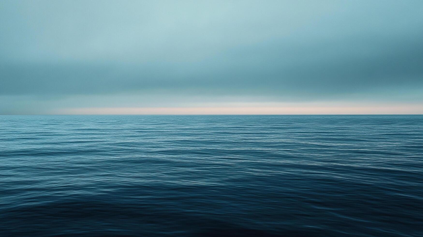 Vast expanse of open ocean waters with a serene blue sky. The horizon line blurs with the clouds creating a seamless and atmospheric scene. photo