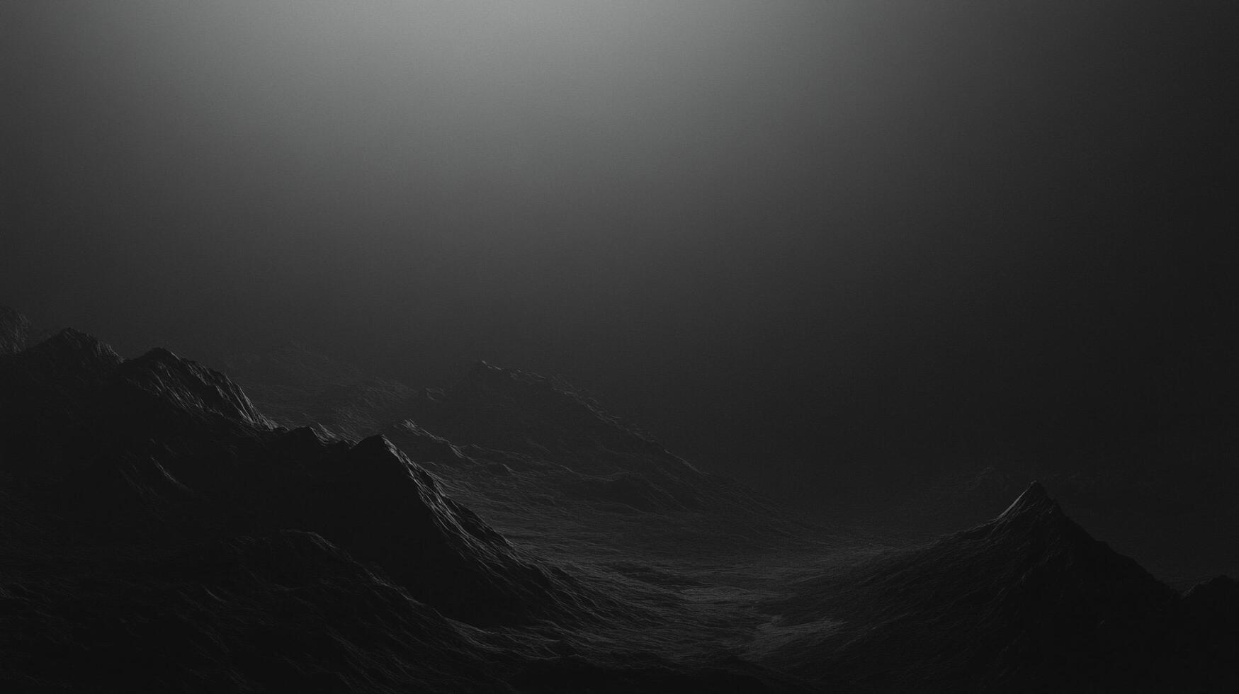 Mysterious, moody landscape of stark, dark mountain range under a gradient of deep shadows and a subtle glow from the sky above. photo