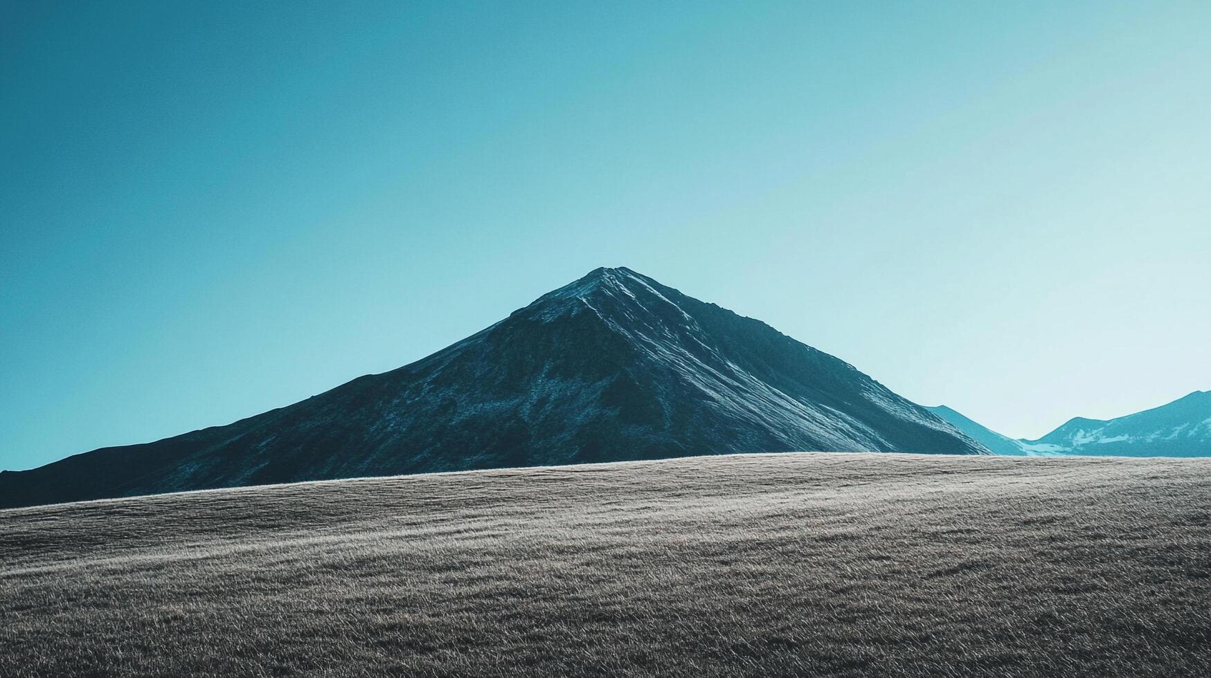Scenic view of a majestic mountain peak against a clear, bright blue sky, showcasing the beauty of nature's grandeur and serene landscape. photo