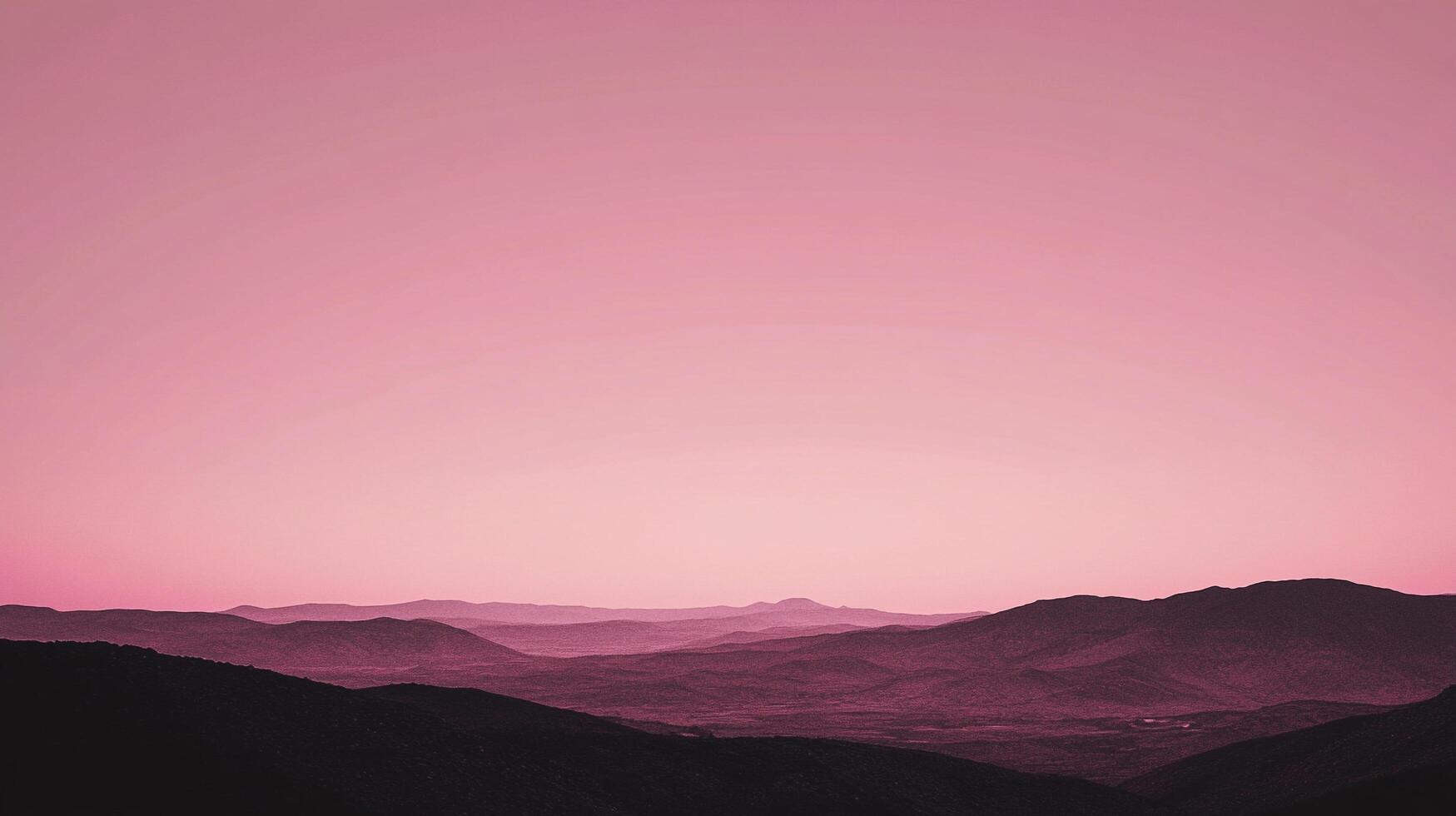 A serene, pink-hued landscape of silhouetted mountains against a soft gradient sky evokes tranquility and natural beauty. photo