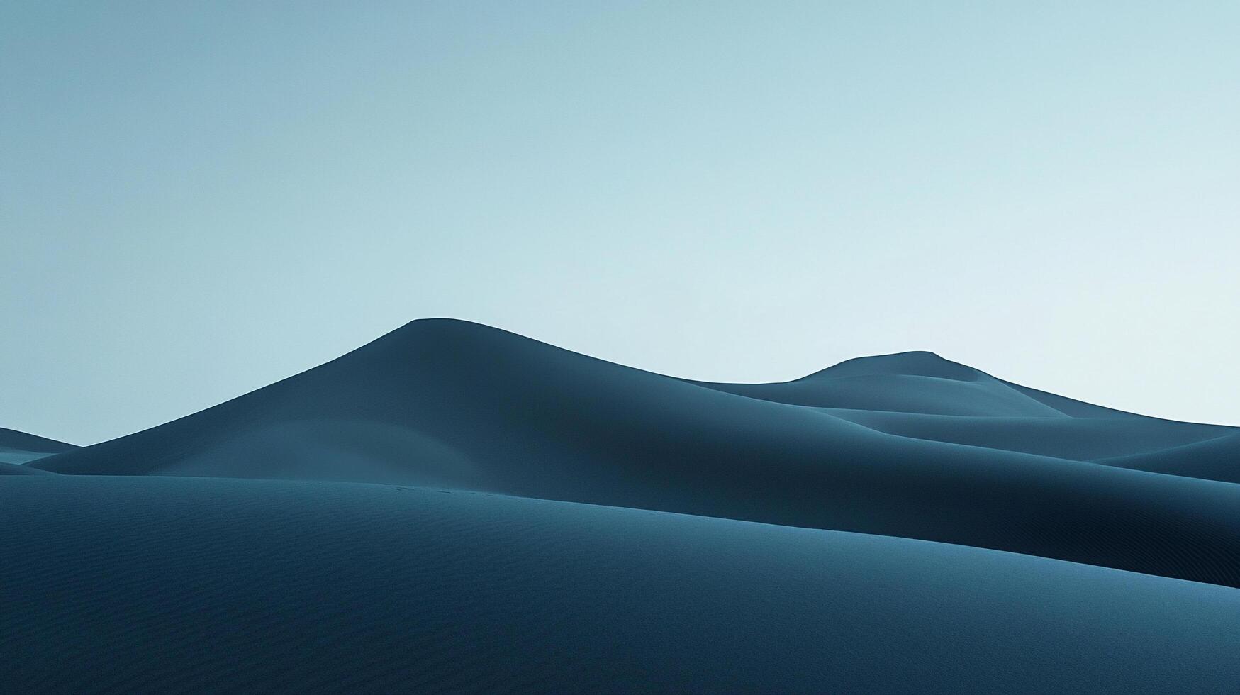 Serene blue sand dunes stretch toward a pale sky, creating a minimalistic and peaceful landscape. The smooth contours evoke a sense of calm. photo