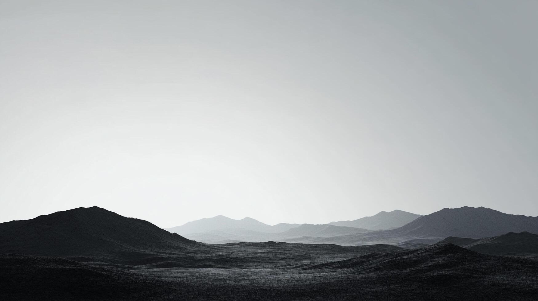 Monochromatic landscape featuring layered mountain ranges, with a hazy sky creating a serene and contemplative atmosphere. photo