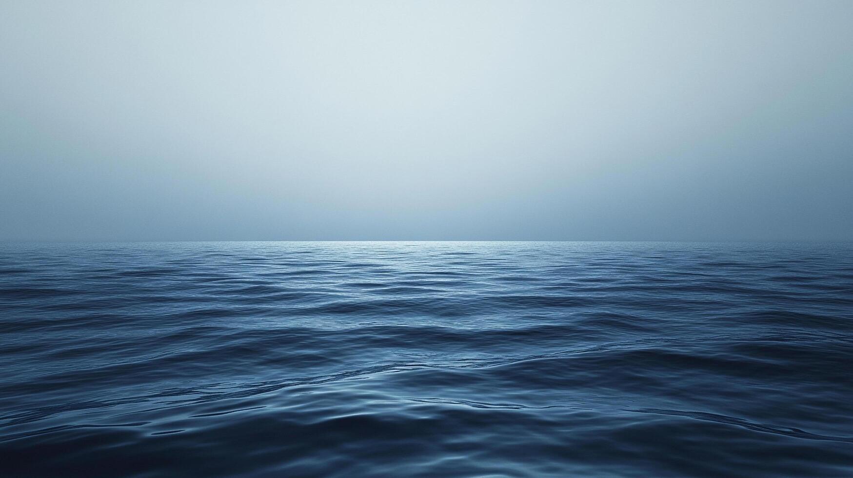 Vast expanse of ocean water under a muted sky, creating a sense of serenity, mystery, and the powerful beauty of the sea. Waves visible. photo