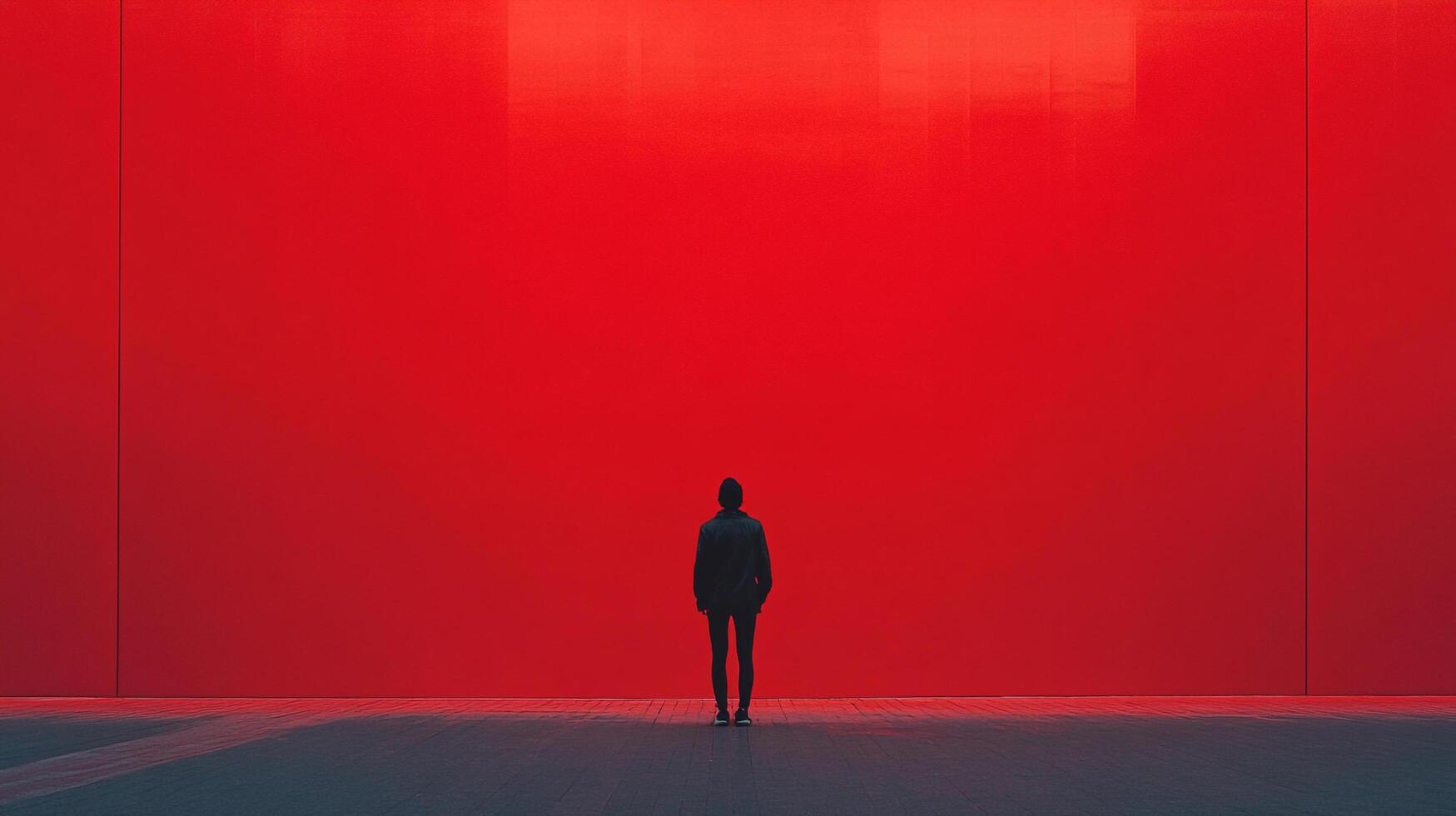 Figure stands before a large, imposing red wall, emphasizing solitude and reflection. Minimalist aesthetic, strong contrast, and stark simplicity. photo