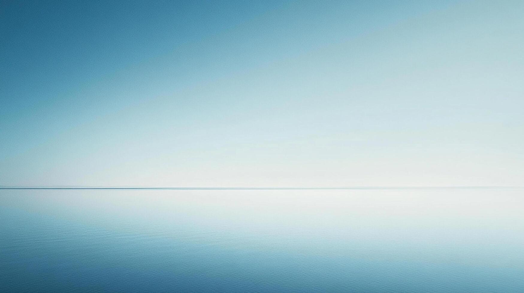 Serene seascape with tranquil waters meeting a pale sky along the horizon. Soft blues create a minimalist and calming atmosphere. photo