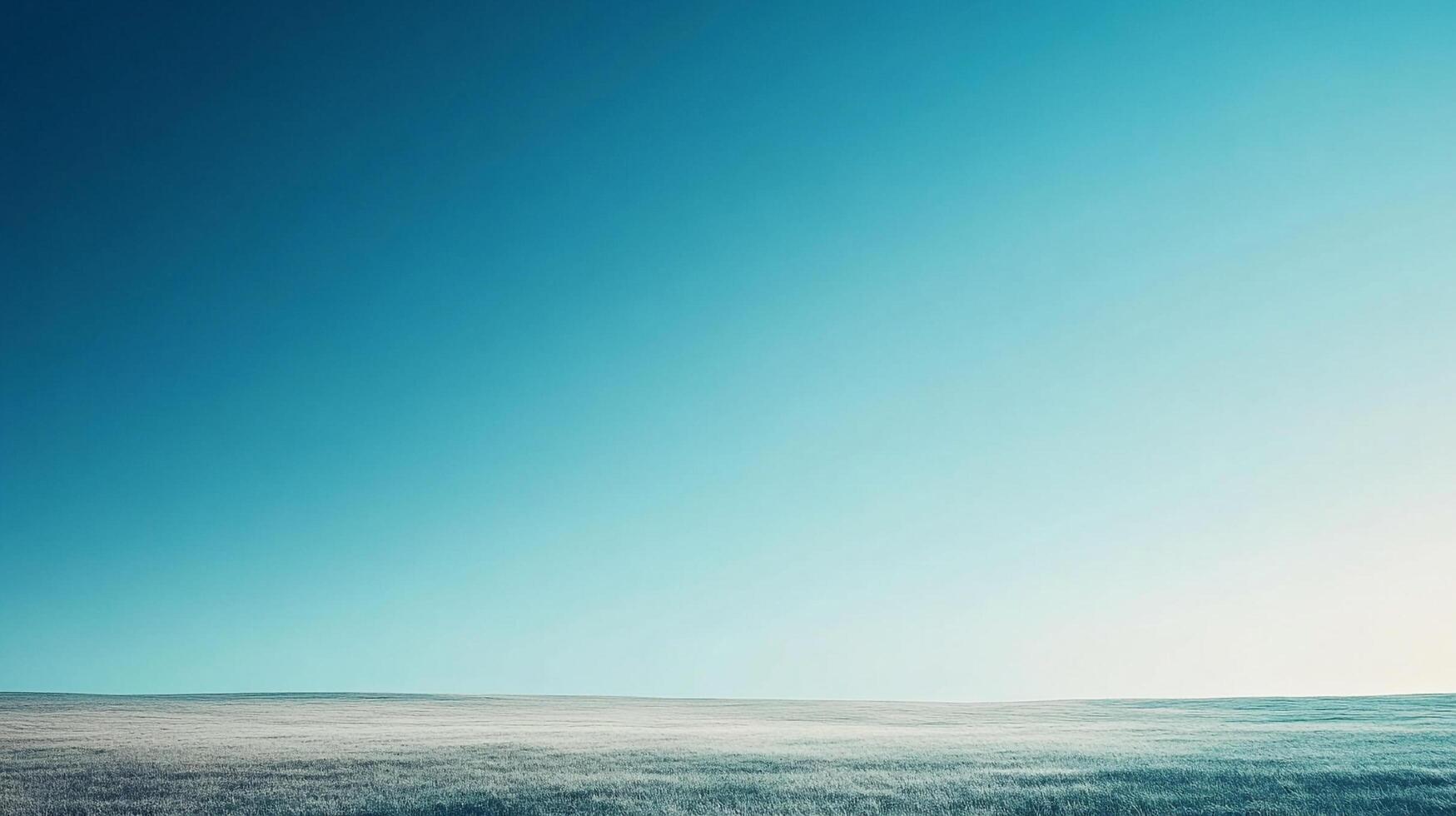Vast open field meets a gradient sky. A tranquil landscape with a gentle color transition from earth to atmosphere. Peaceful vista. photo
