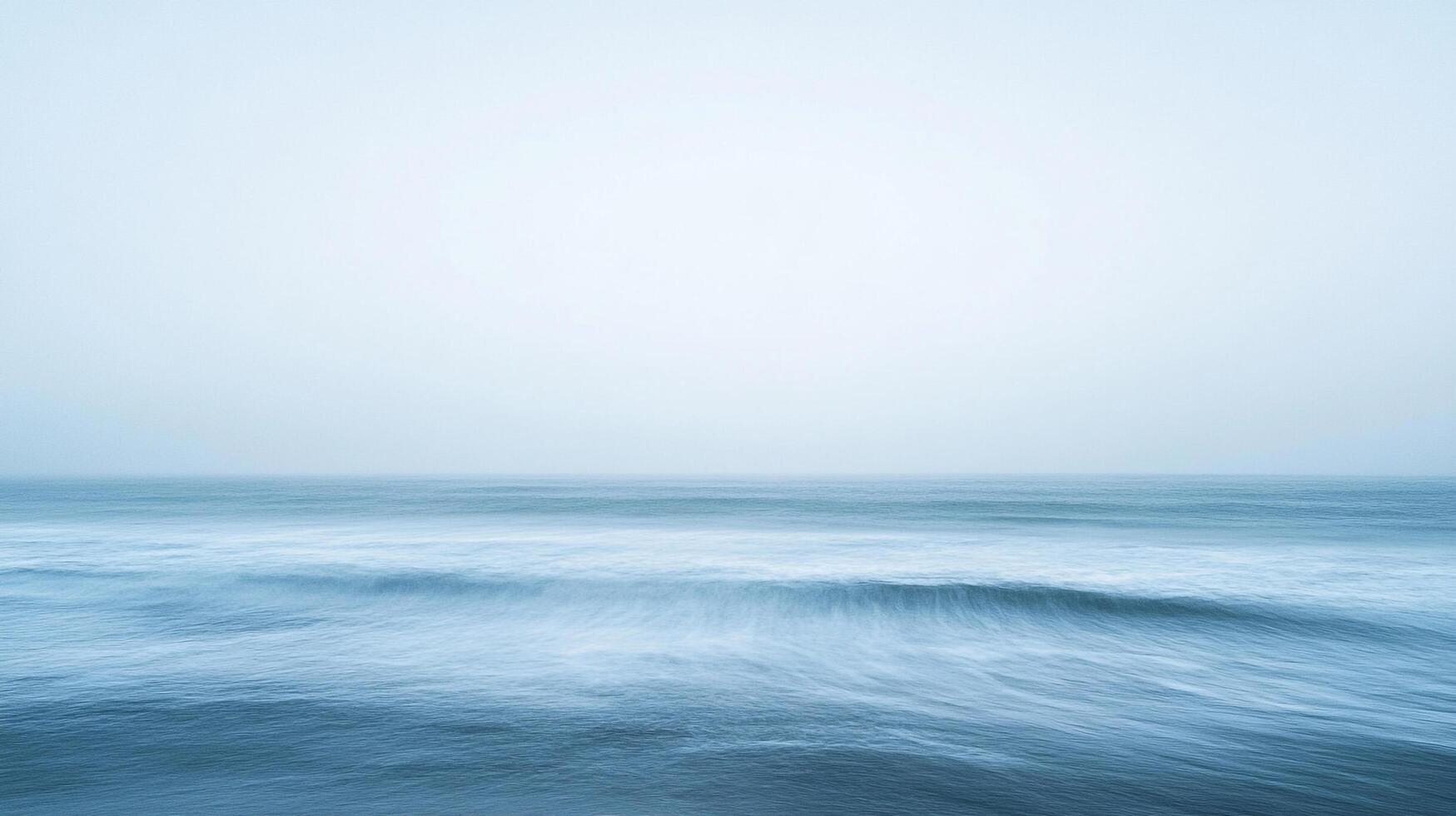 Calming ocean view with soft waves, captured in a serene long exposure, creates a peaceful and minimalist seascape on the horizon. photo