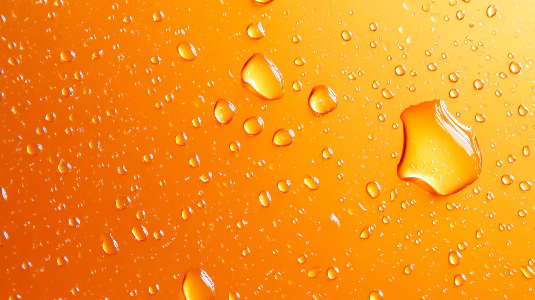 Water droplets cascade across an orange surface, creating a refreshing and vibrant textured background with a sense of pure hydration. photo