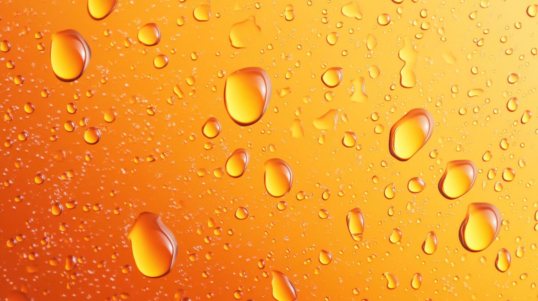 Water droplets cling to a vibrant orange surface, creating a refreshing and visually appealing texture. A macro shot reveals details. photo