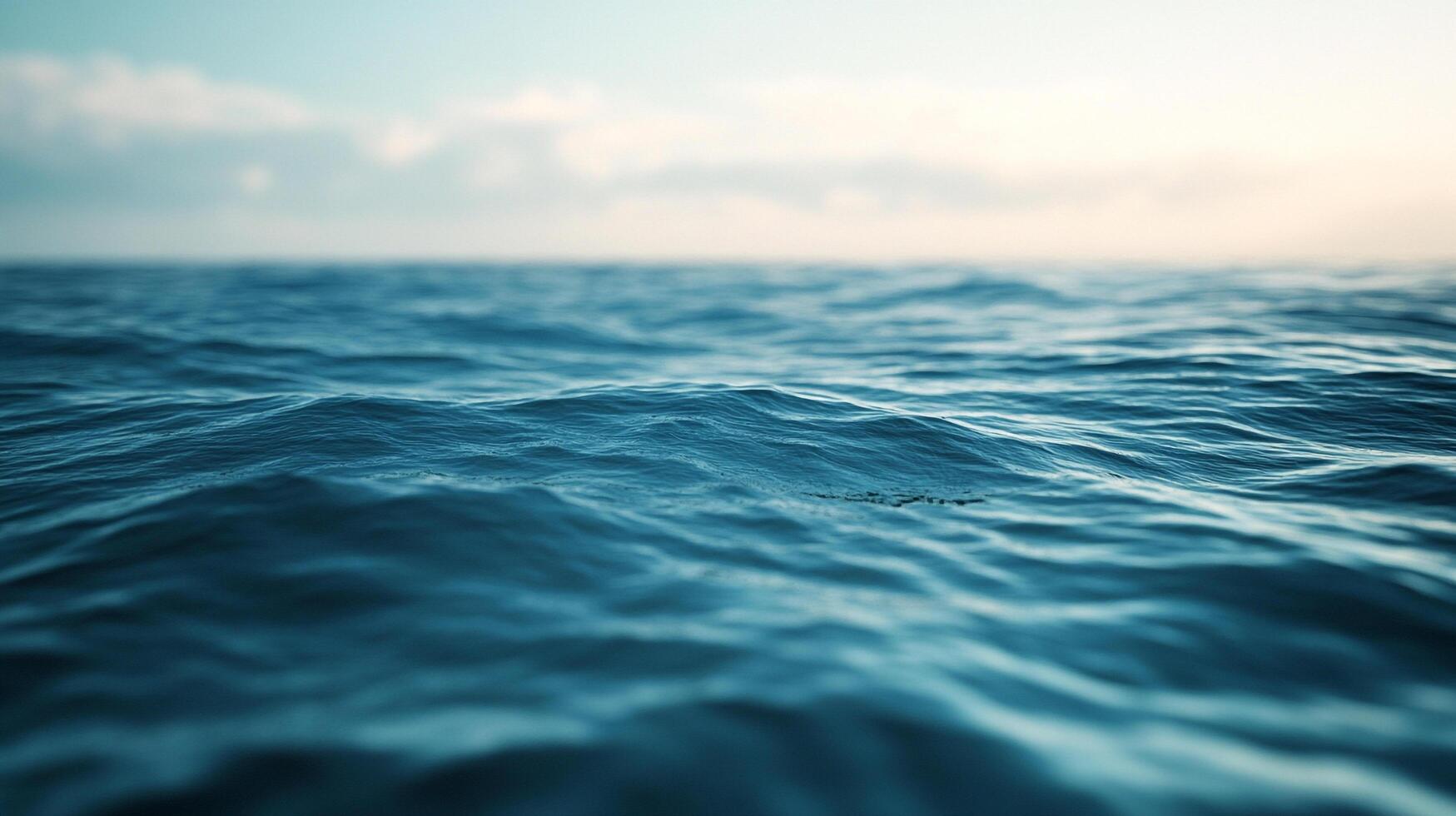 Vast expanse of deep blue ocean water, rippling with small waves, under a soft sky. Gentle motion and a tranquil, natural background. photo