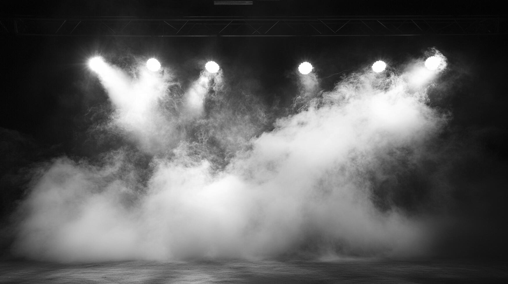 Stage lights pierce through dense fog, creating a dramatic, black and white ambiance. The atmosphere is thick with mystery. photo