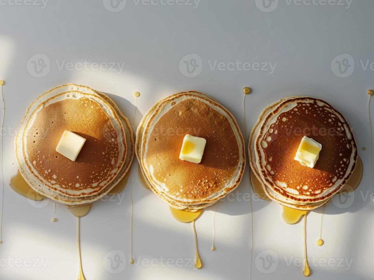 Three pancakes with butter and syrup on top photo