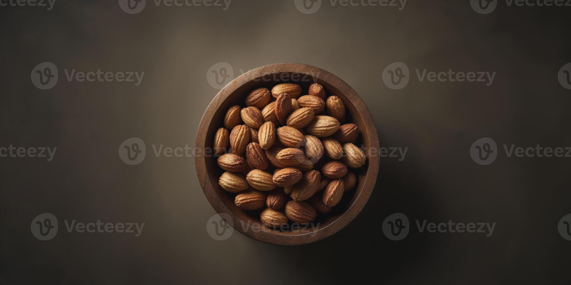 Almonds in a wooden bowl on a dark background photo