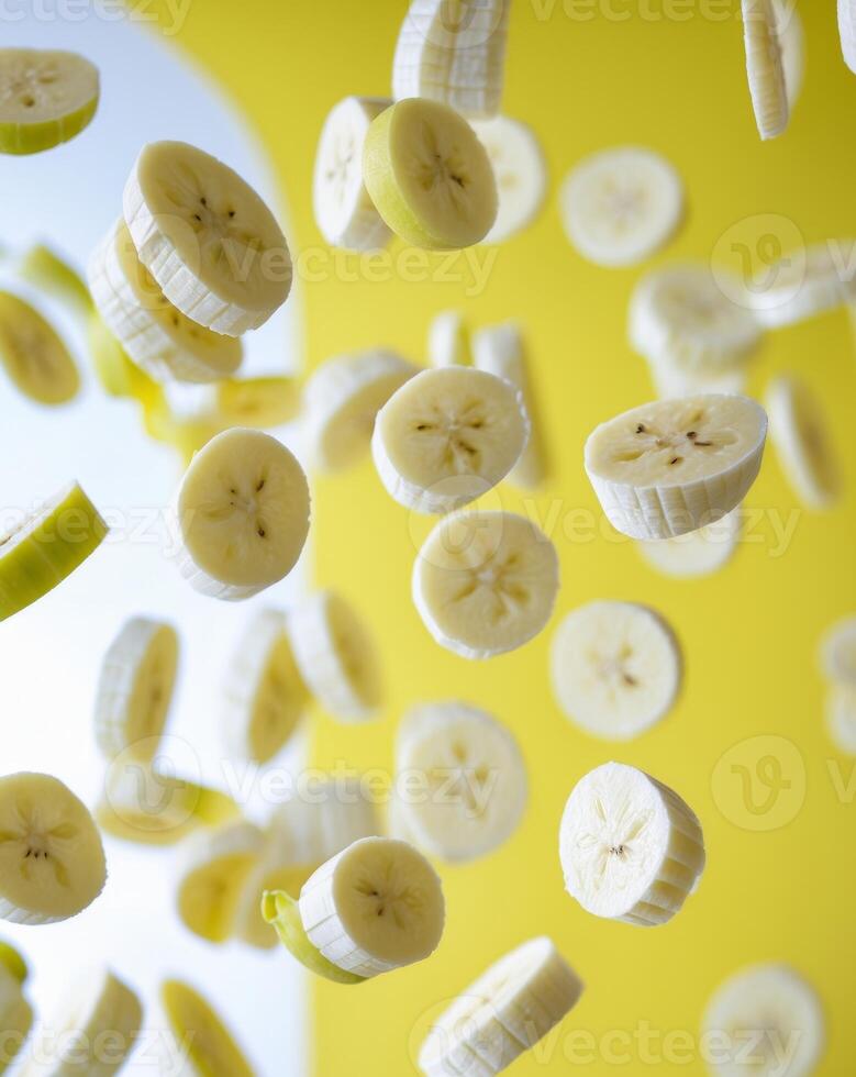 Sliced Bananas Floating Above Yellow Background in Creative Arrangement. photo