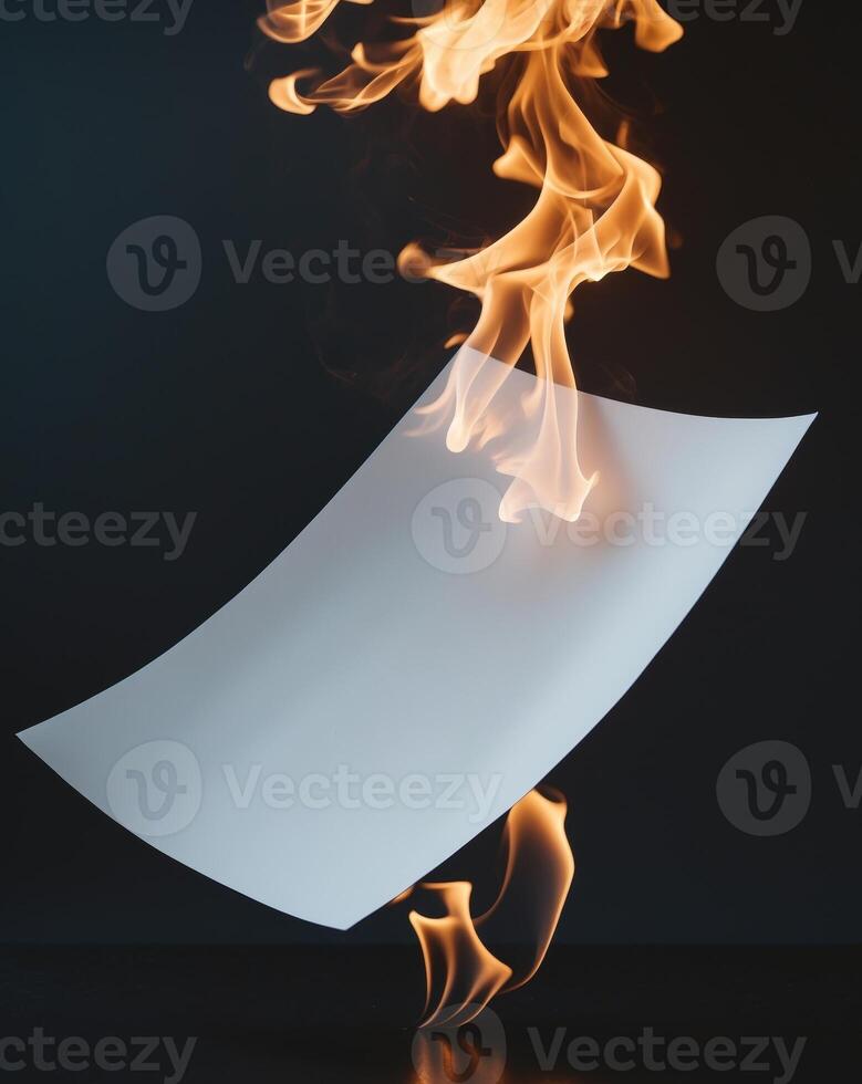 White piece of paper is on a black background with a fire burning behind it photo