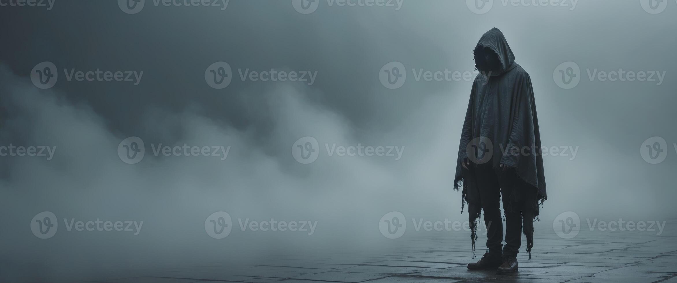 Mysterious Figure in a Hooded Cloak Amidst a Dark and Foggy Atmosphere photo