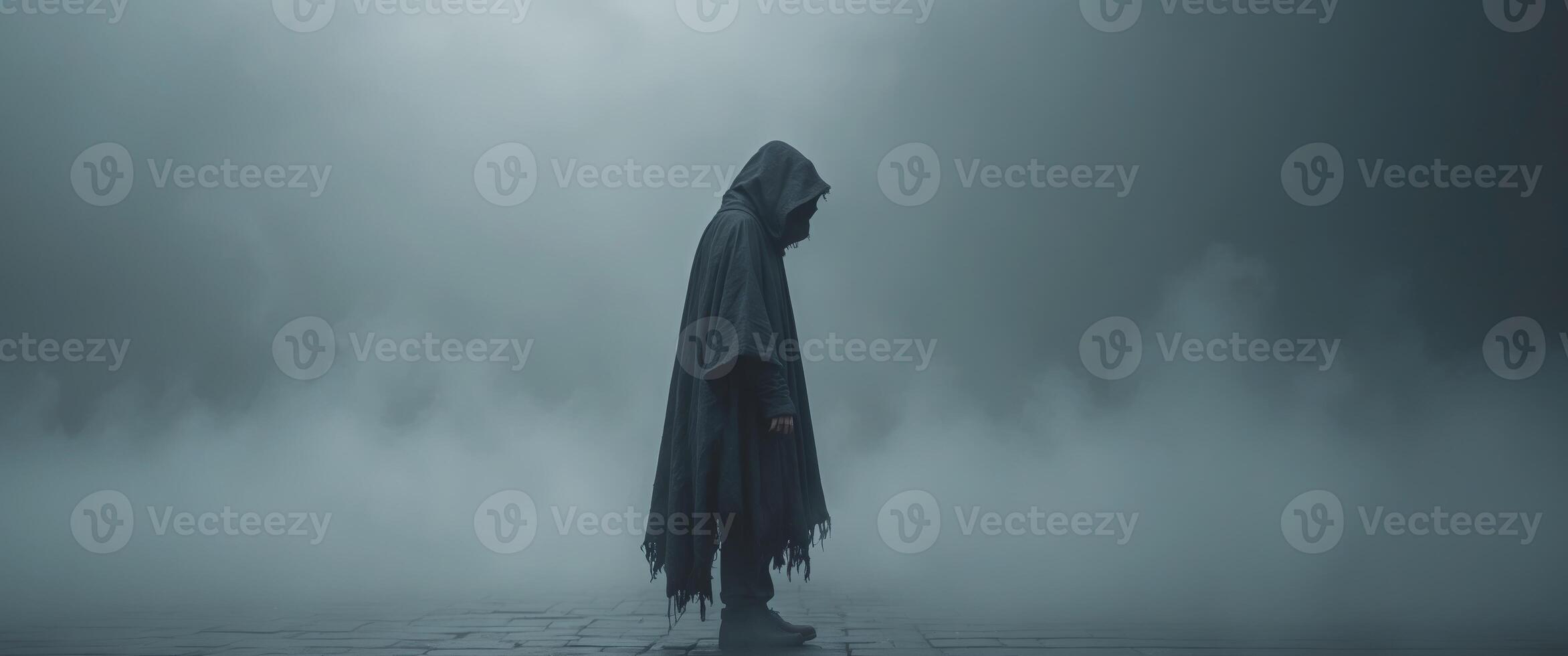 Mysterious Figure in a Hooded Cloak Amidst a Dark and Foggy Atmosphere. photo