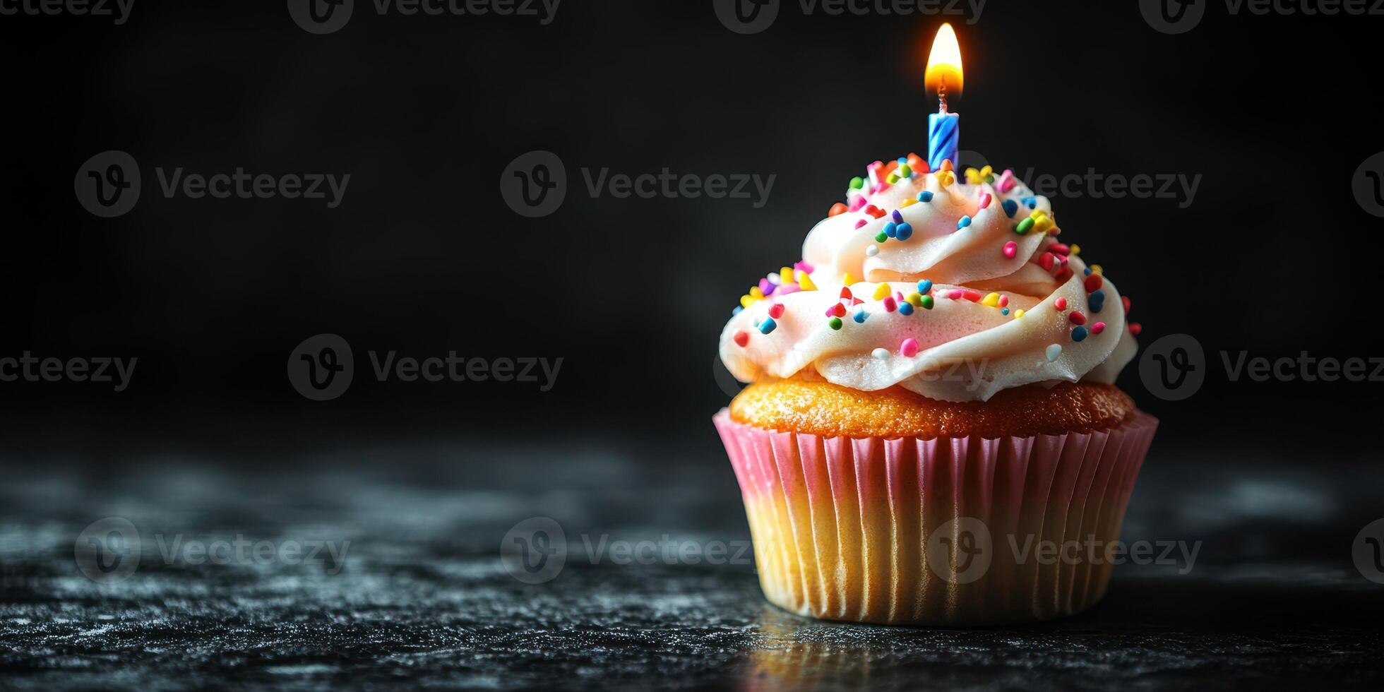 Brightly lit cupcake with colorful frosting and a candle stands out against a dark background for a festive celebration photo