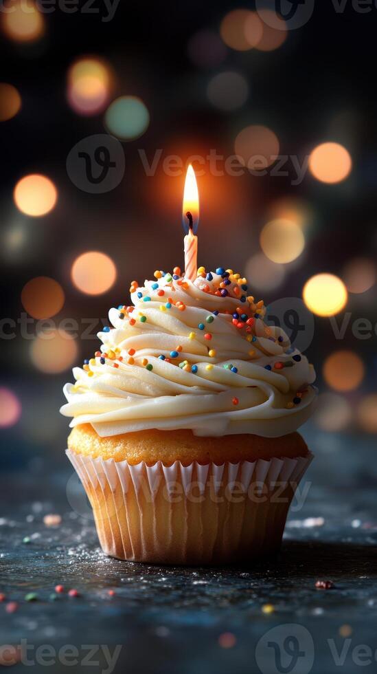Colorful cupcake with candle and festive bokeh background celebrating a birthday at nighttime photo