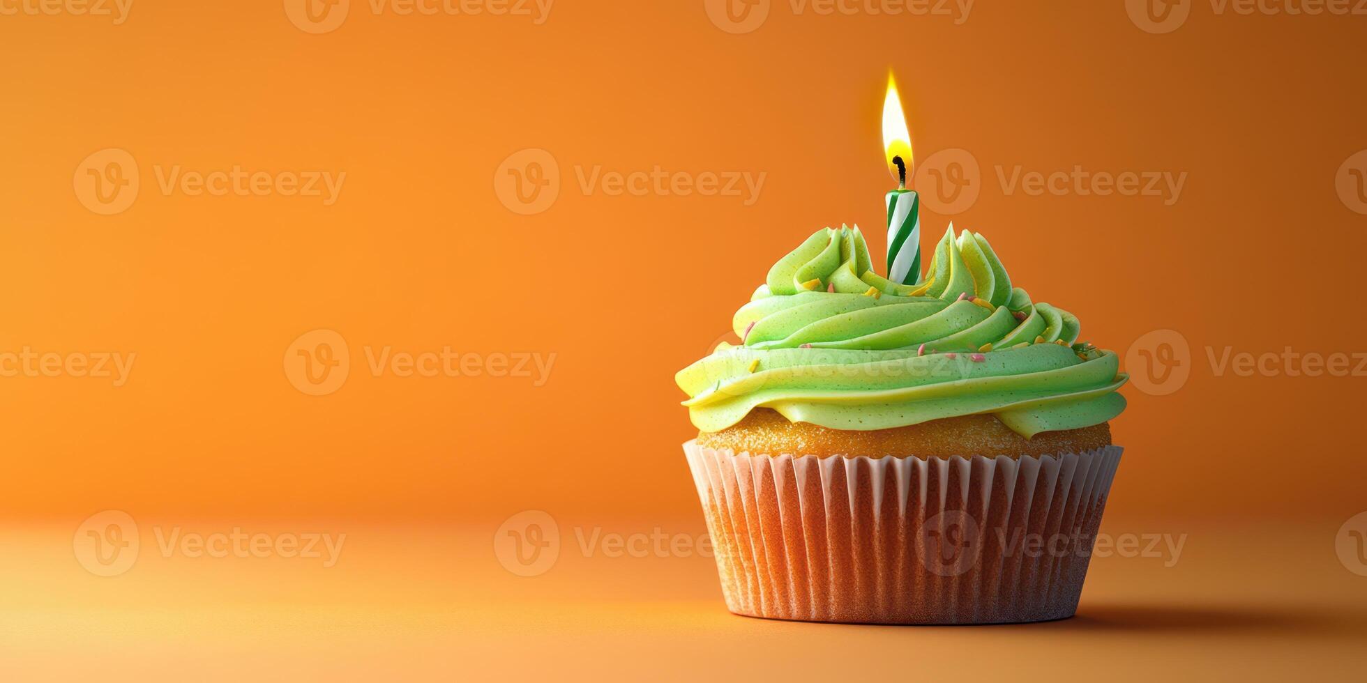 Celebratory cupcake with green frosting and a candle on a bright orange background for a festive occasion photo