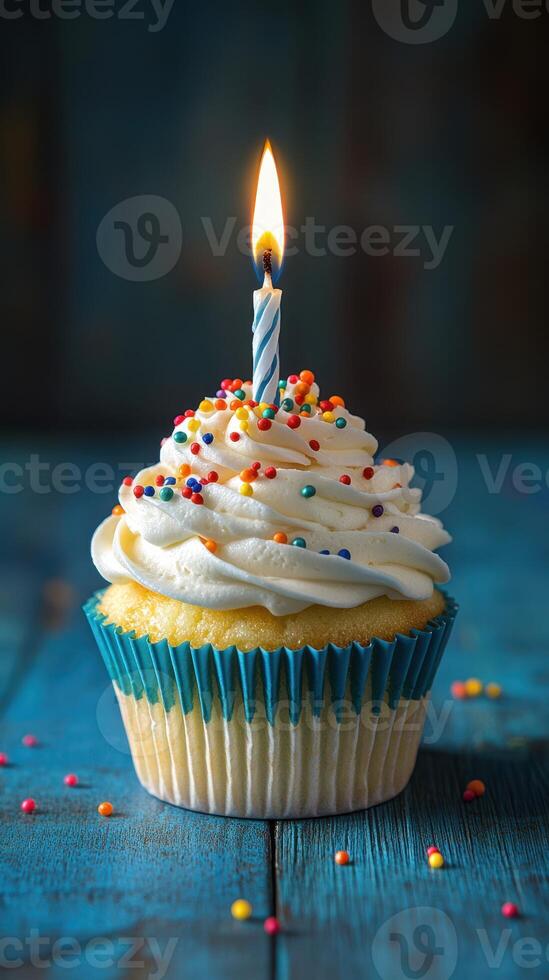 Colorful cupcake with a single candle burning on top, ready for celebration in a cozy setting photo