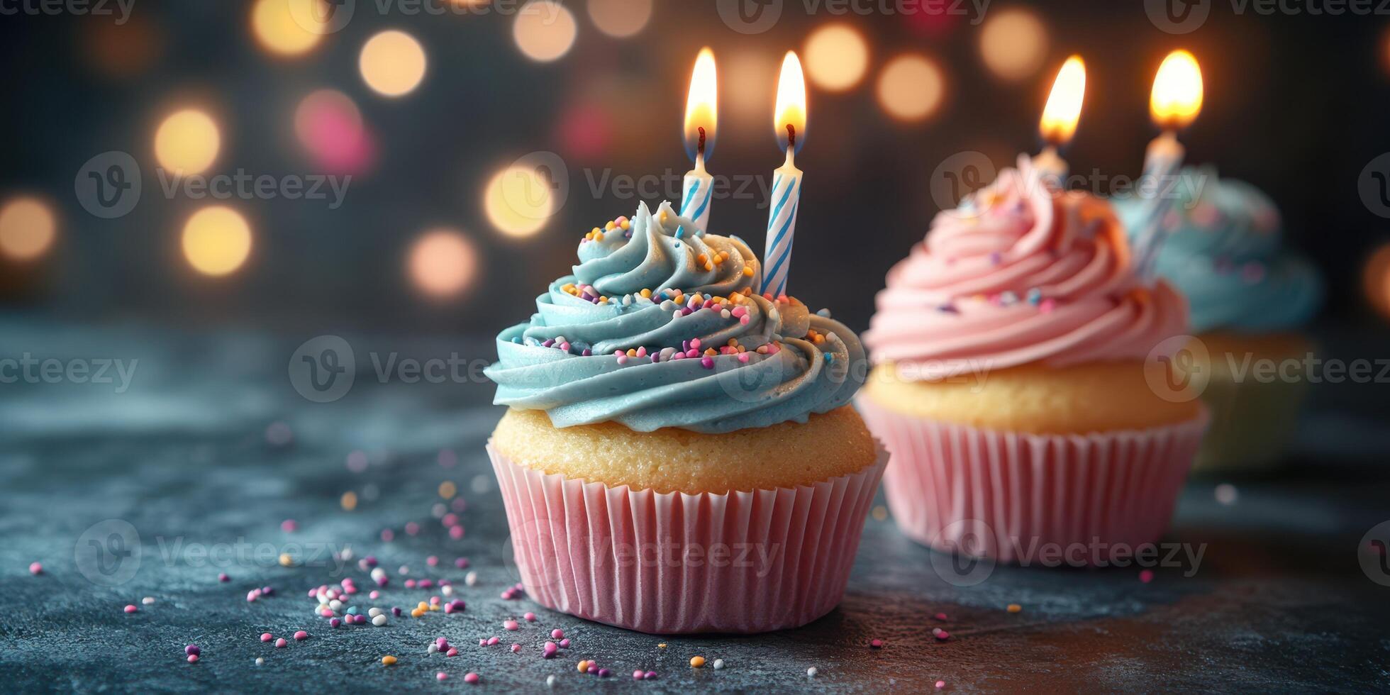 Delicious cupcakes with blue and pink frosting and candles on a festive table during a birthday celebration photo