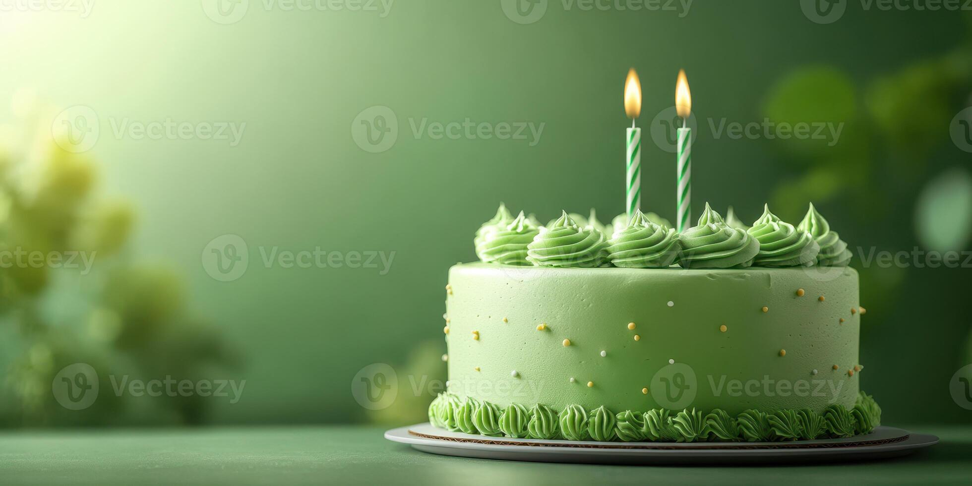 Green cake with two lit candles on a decorative table in a cozy indoor setting during a celebration photo