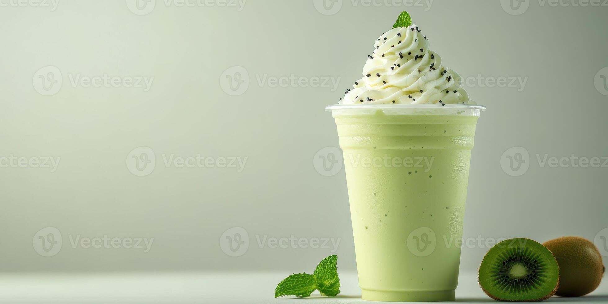 Refreshing green smoothie topped with whipped cream and mint in a clear cup on a light background photo