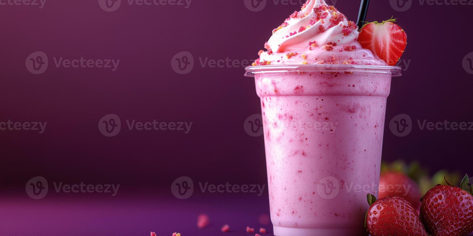 Refreshing strawberry shake topped with whipped cream and strawberry pieces served in a clear cup photo