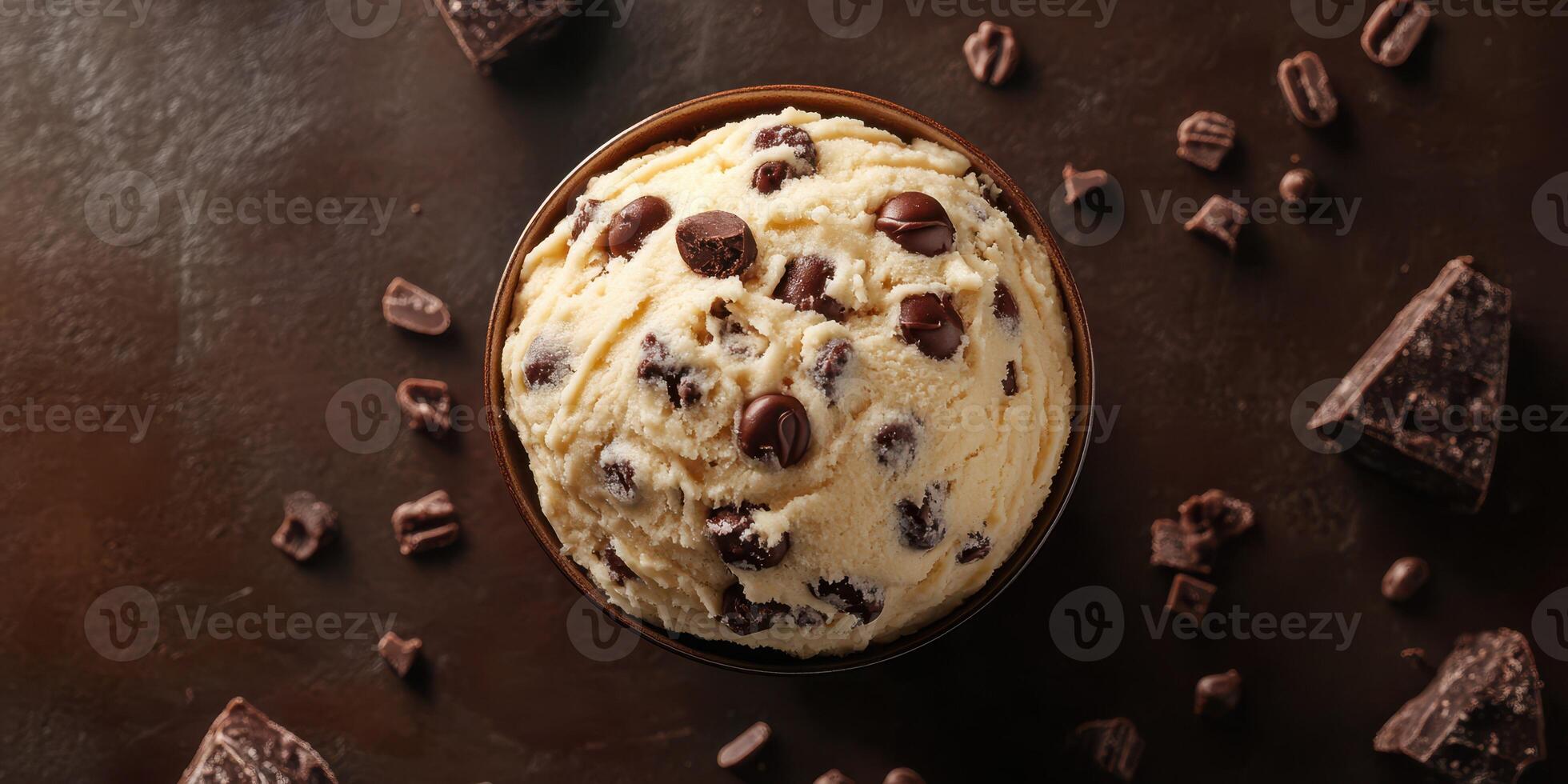Delightful bowl of chocolate chip ice cream surrounded by chocolate pieces captured in a cozy setting photo
