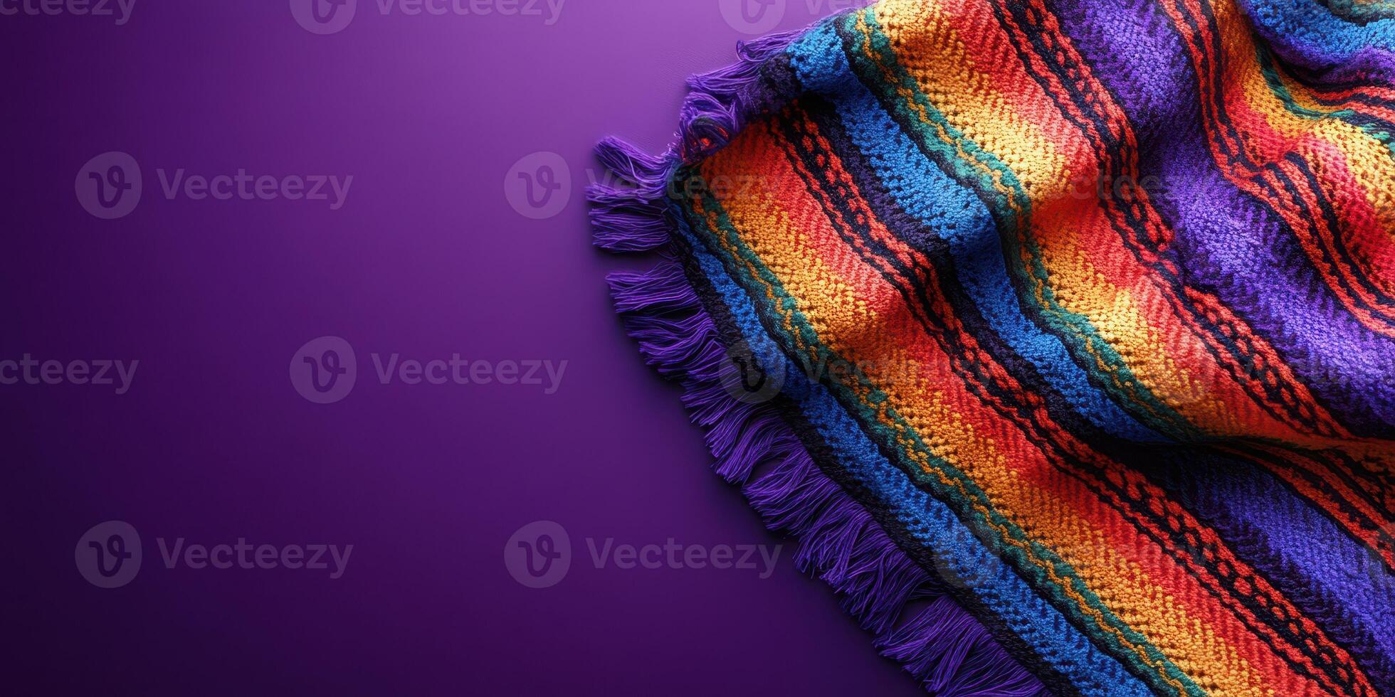 Colorful handmade blanket draped on a purple background showcasing vibrant stripes and textures photo