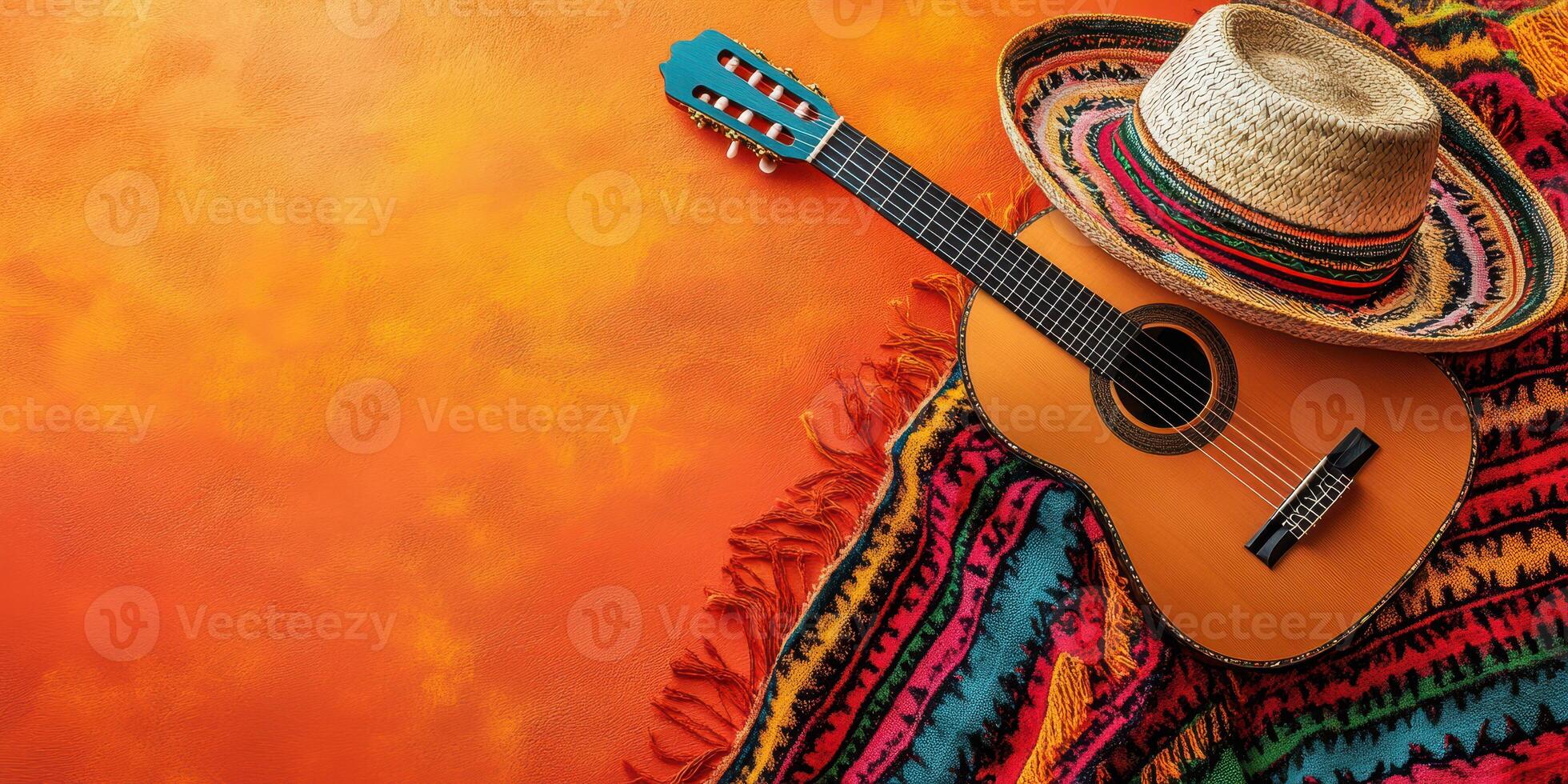 Colorful sombrero and acoustic guitar placed on vibrant woven blanket against warm orange background photo