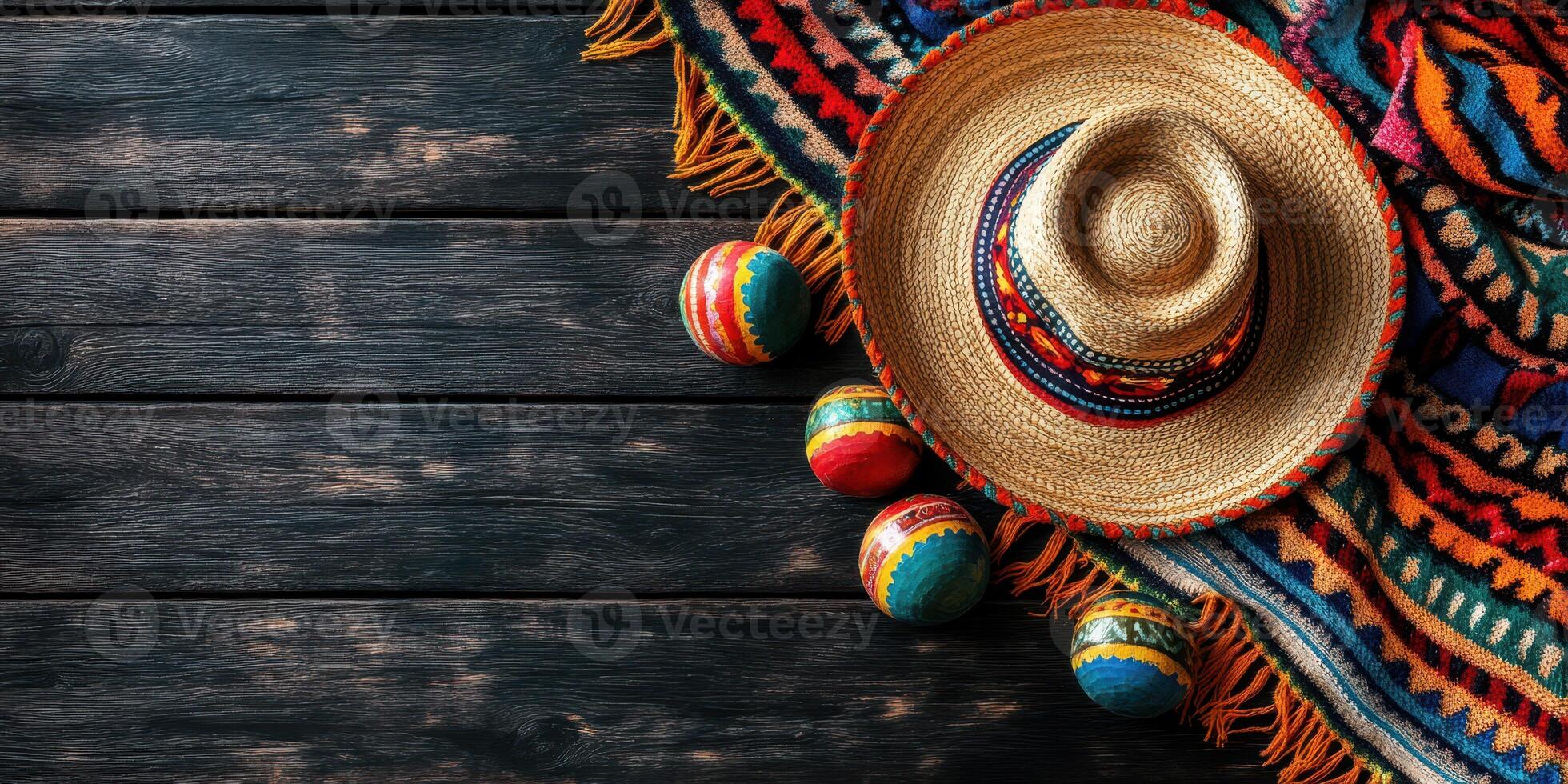 Colorful sombrero and traditional textiles arranged with decorative balls on dark wooden surface photo
