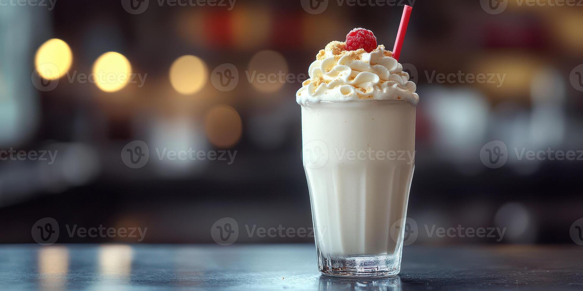 Refreshing milkshake topped with whipped cream and raspberry served in a classic glass photo