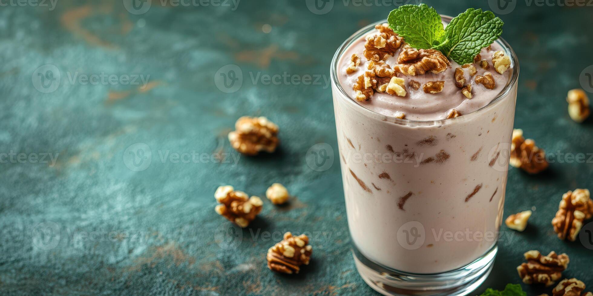Creamy dessert topped with crunchy nuts and fresh mint leaves on a textured background photo