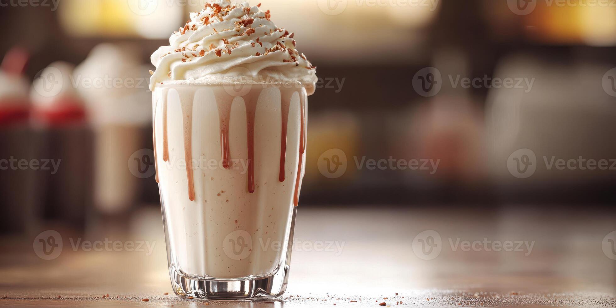 Creamy milkshake topped with whipped cream and caramel drizzle on a wooden table in a cafe setting photo