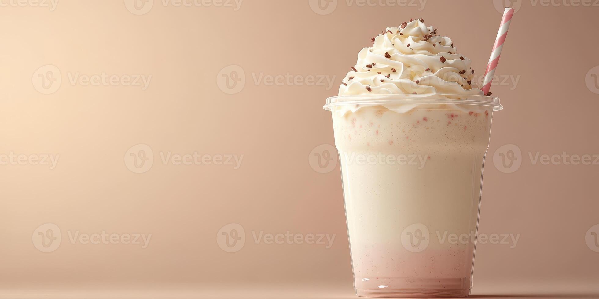 Delicious creamy milkshake topped with whipped cream and chocolate sprinkles in a clear cup with a striped straw photo